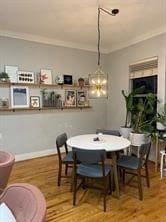 dining room with wood-type flooring and crown molding