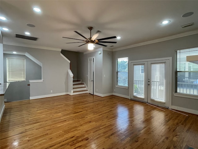 empty room with hardwood / wood-style floors, ceiling fan, crown molding, and a healthy amount of sunlight