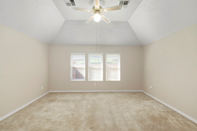 spare room with vaulted ceiling, ceiling fan, and light colored carpet