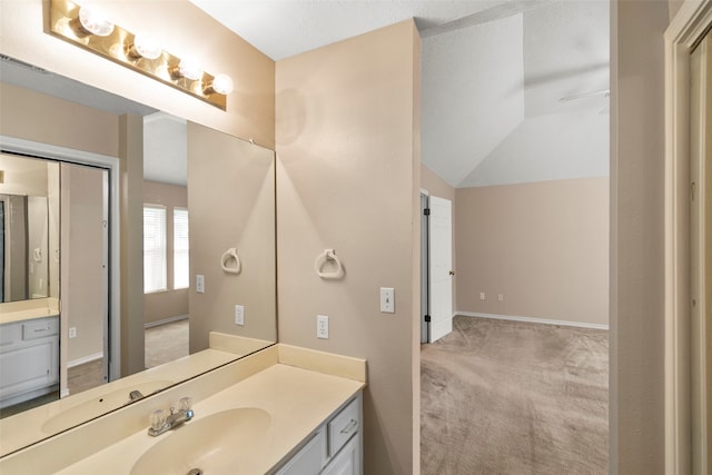 bathroom featuring lofted ceiling and vanity