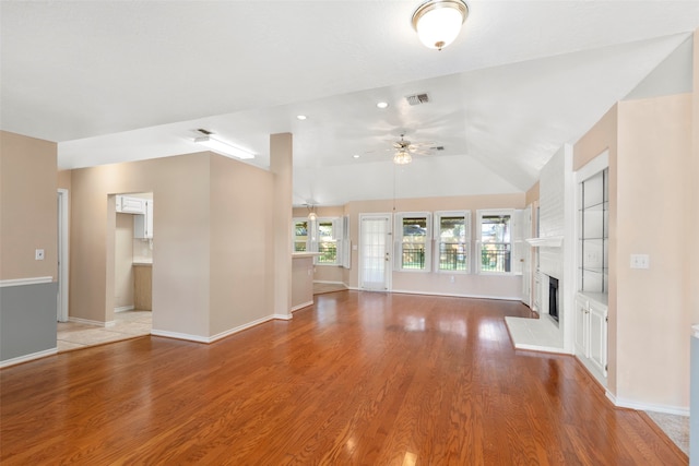 unfurnished living room featuring ceiling fan, light hardwood / wood-style flooring, and vaulted ceiling