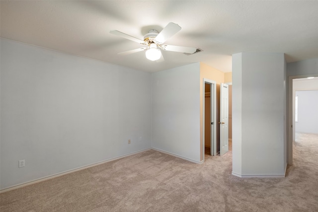 spare room featuring ceiling fan and light colored carpet