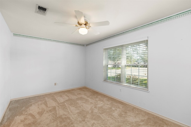 empty room featuring ceiling fan and light colored carpet