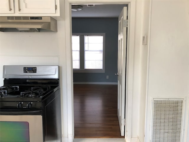 kitchen with hardwood / wood-style floors, gas stove, white cabinetry, and exhaust hood