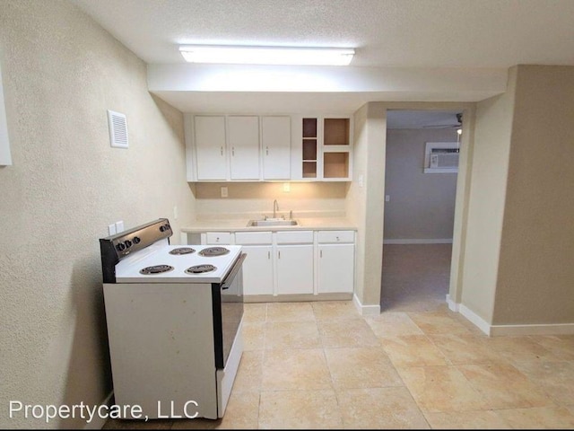 kitchen with white cabinets, sink, a textured ceiling, white electric range, and a wall mounted air conditioner