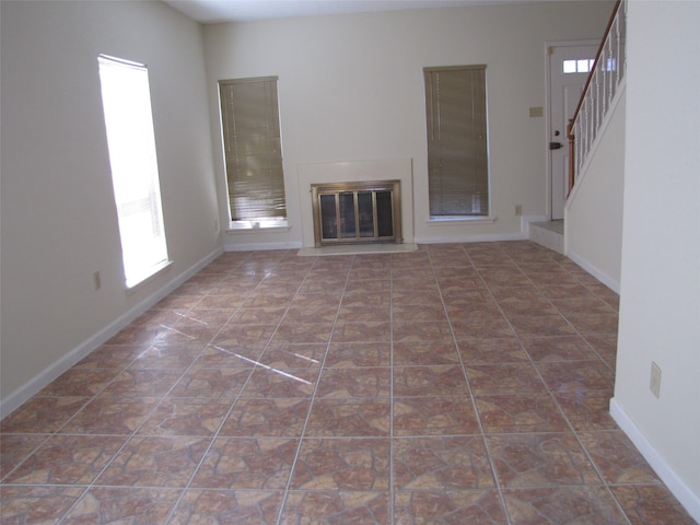 unfurnished living room featuring dark tile patterned floors