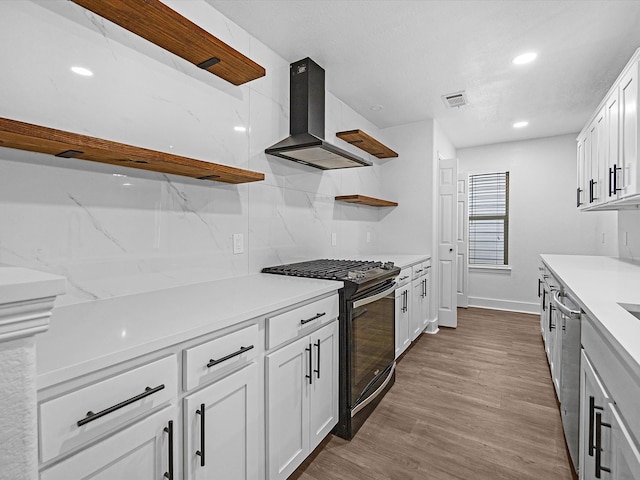 kitchen with white cabinetry, exhaust hood, and black range with gas cooktop