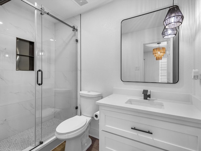 bathroom with a chandelier, a shower with door, hardwood / wood-style floors, vanity, and toilet