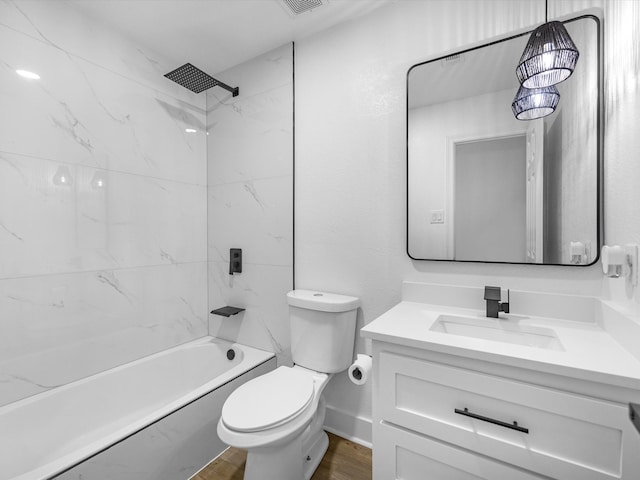 full bathroom with hardwood / wood-style floors, tiled shower / bath combo, vanity, and toilet