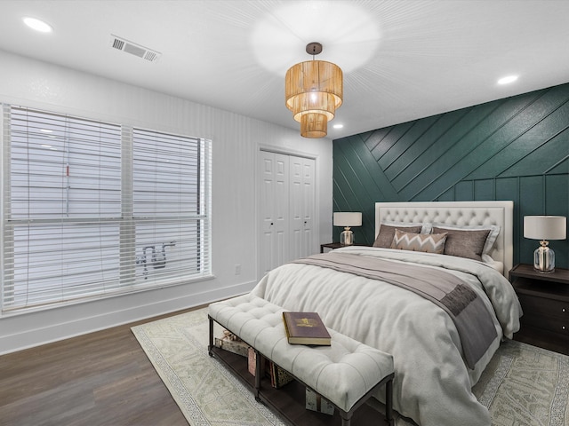 bedroom with an inviting chandelier, hardwood / wood-style flooring, and a closet