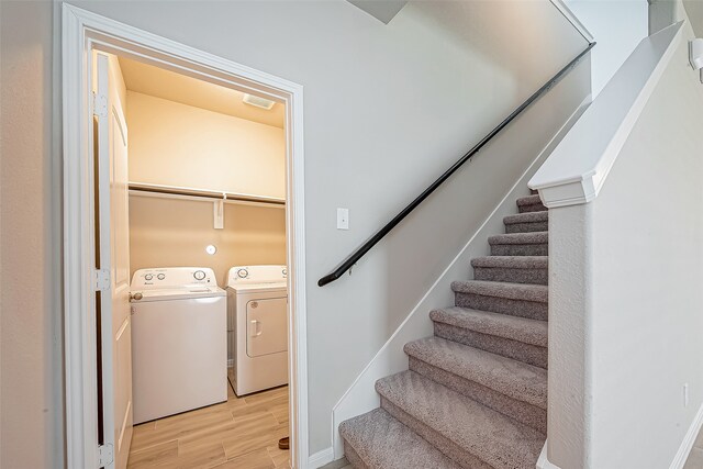 clothes washing area with light wood-type flooring and independent washer and dryer