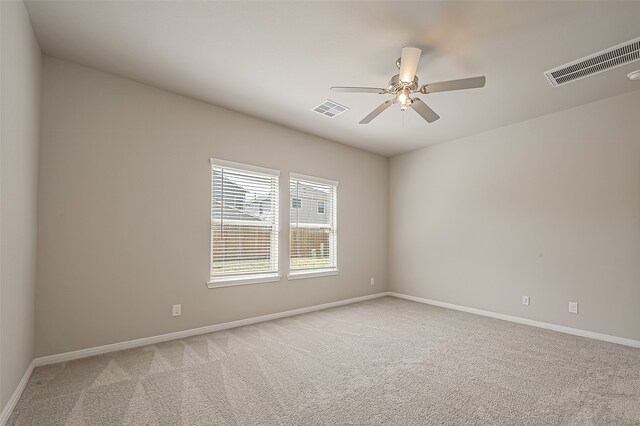 carpeted spare room featuring ceiling fan