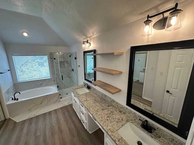 bathroom with vanity, a textured ceiling, separate shower and tub, hardwood / wood-style floors, and lofted ceiling