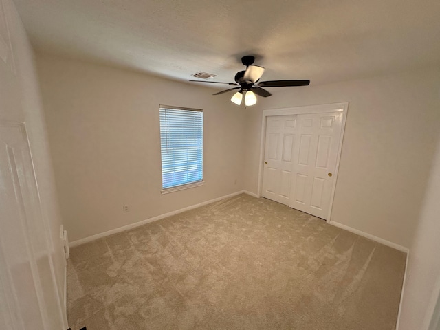 empty room featuring light carpet and ceiling fan