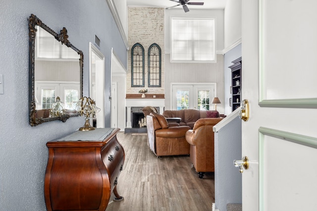 living room featuring a high ceiling, ceiling fan, hardwood / wood-style flooring, and french doors