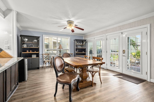 dining area featuring ceiling fan, light hardwood / wood-style floors, french doors, and crown molding