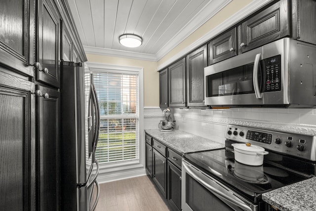 kitchen featuring light stone counters, tasteful backsplash, wood-type flooring, appliances with stainless steel finishes, and crown molding