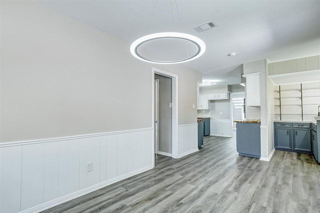 unfurnished living room with built in features and light wood-type flooring