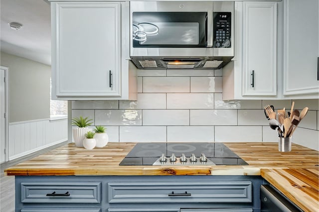 kitchen featuring white cabinetry, butcher block countertops, and black appliances