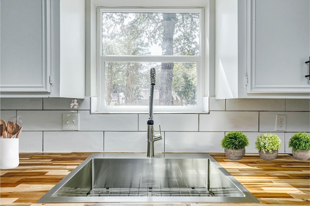 details with tasteful backsplash, sink, and white cabinets