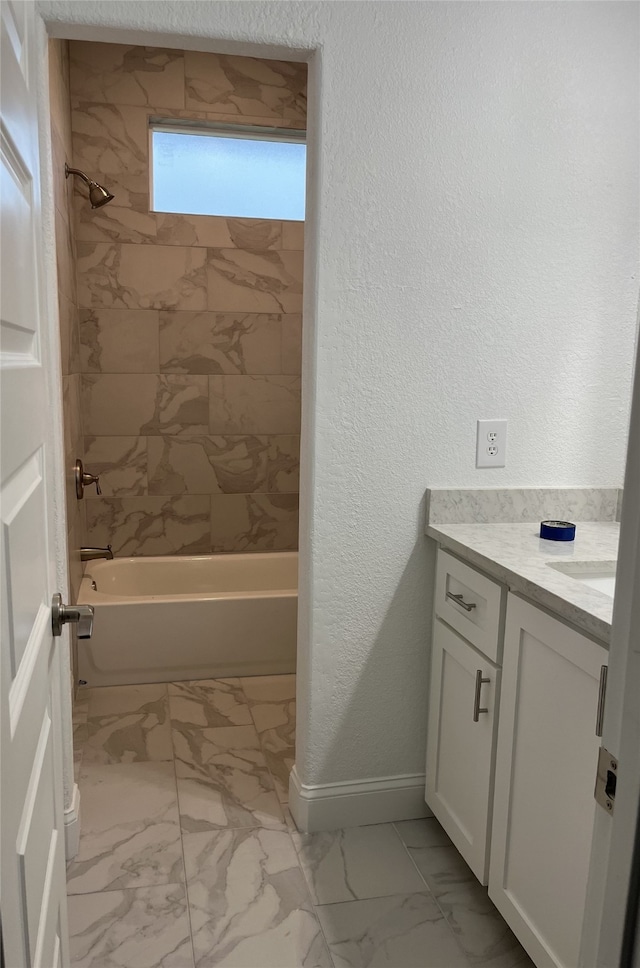 bathroom featuring tiled shower / bath and vanity