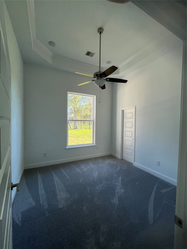 carpeted empty room with a tray ceiling and ceiling fan