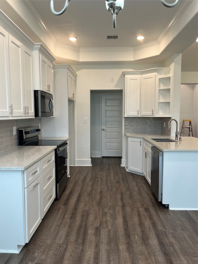 kitchen featuring dark wood-type flooring, white cabinetry, stainless steel appliances, and a raised ceiling