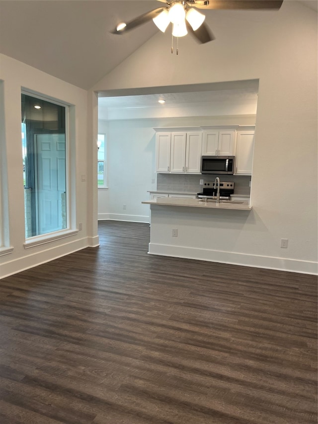 unfurnished living room featuring lofted ceiling, dark wood-type flooring, sink, and ceiling fan