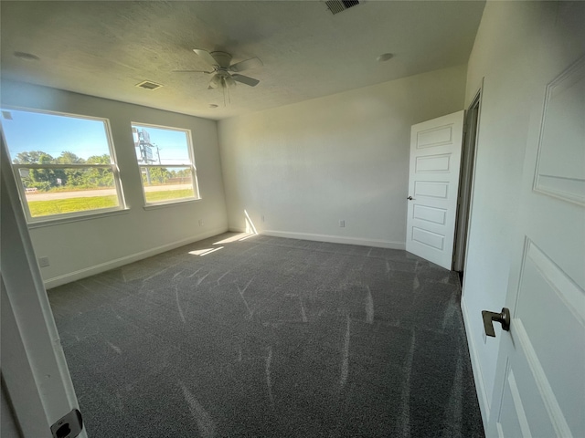 carpeted spare room with ceiling fan