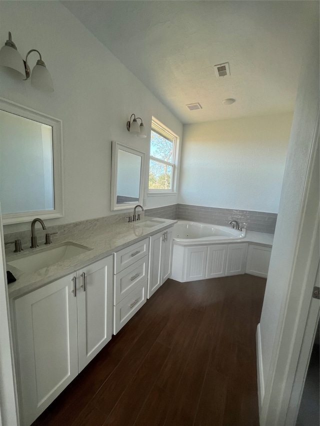 bathroom with vanity, a bathtub, and hardwood / wood-style flooring