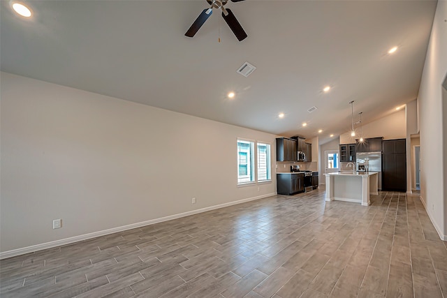 unfurnished living room with ceiling fan, sink, light hardwood / wood-style floors, and high vaulted ceiling