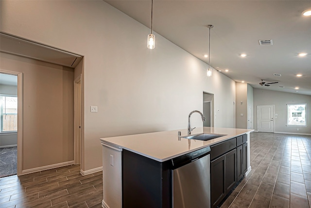 kitchen with lofted ceiling, plenty of natural light, a kitchen island with sink, and sink