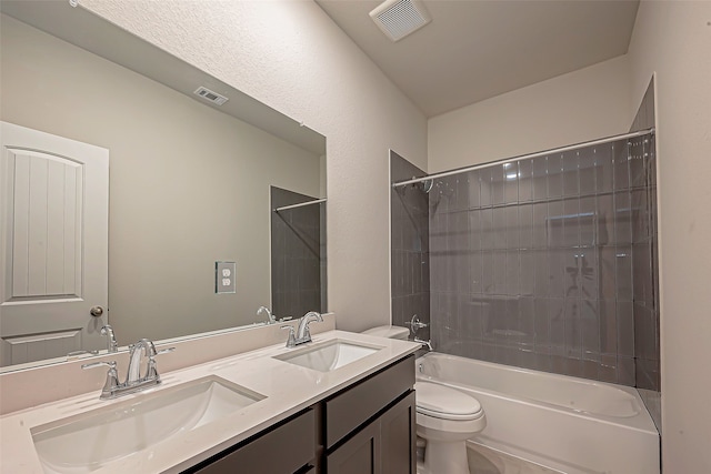 full bathroom featuring tiled shower / bath combo, vanity, and toilet