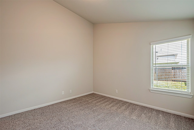 empty room with lofted ceiling and carpet