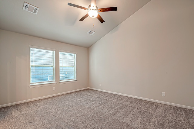 empty room featuring ceiling fan, vaulted ceiling, and carpet