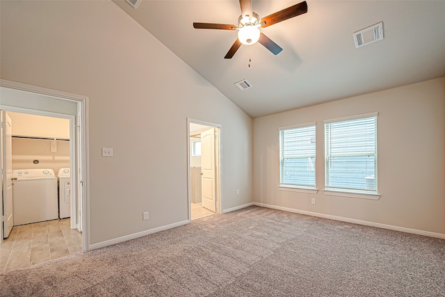 unfurnished bedroom featuring ceiling fan, high vaulted ceiling, light carpet, separate washer and dryer, and ensuite bath