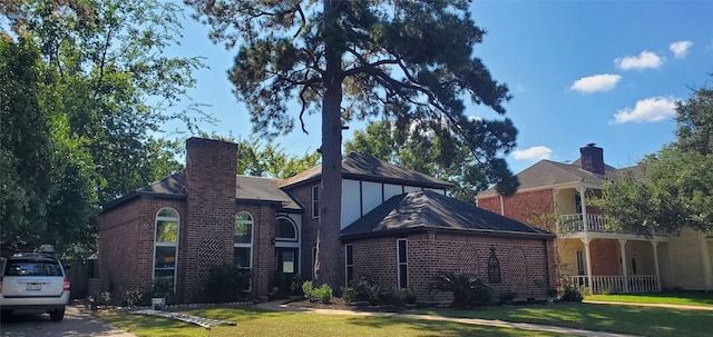 view of front facade with a balcony and a front lawn