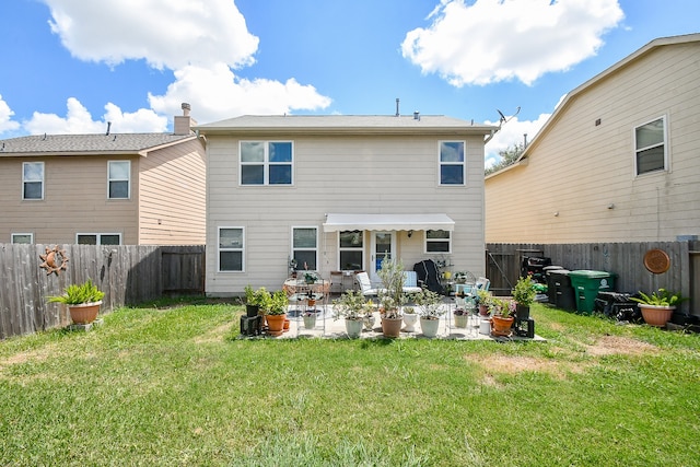 rear view of house featuring a lawn and a patio area