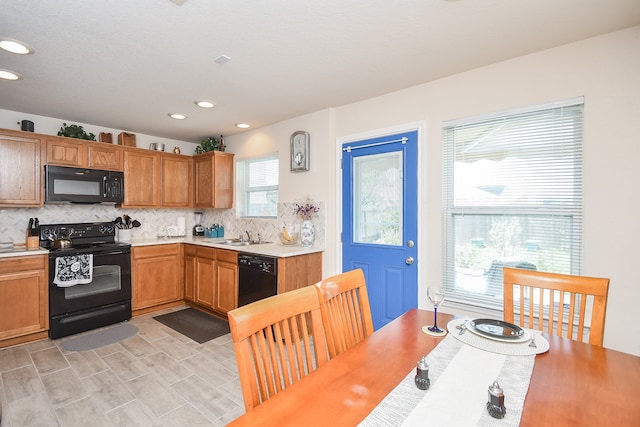 kitchen featuring tasteful backsplash, black appliances, and sink