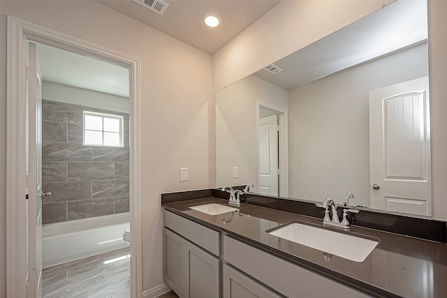 full bathroom featuring vanity, toilet, and tiled shower / bath