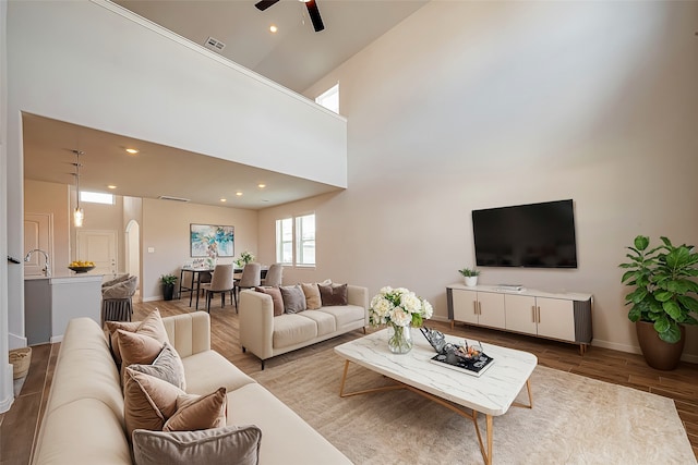 living room with high vaulted ceiling, light hardwood / wood-style flooring, and ceiling fan