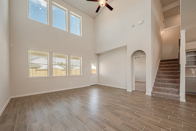 unfurnished living room with high vaulted ceiling, ceiling fan, and hardwood / wood-style floors