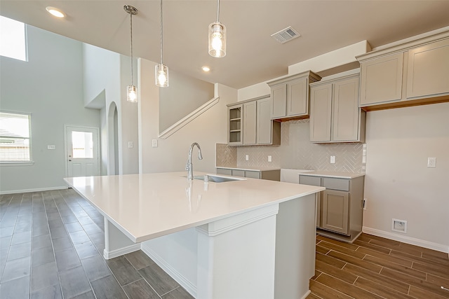 kitchen with pendant lighting, an island with sink, sink, and dark hardwood / wood-style flooring