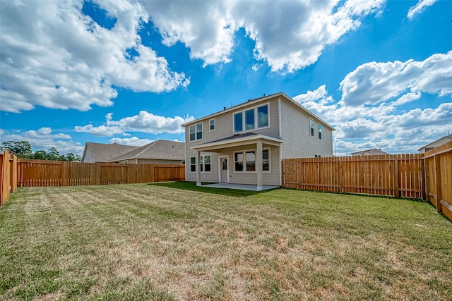 rear view of house with a patio and a yard