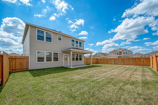 rear view of house featuring a yard and a patio area