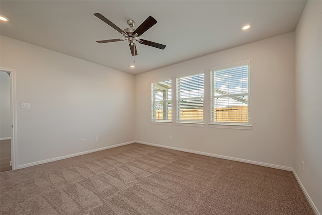 empty room featuring ceiling fan and light colored carpet