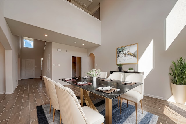 dining area with a high ceiling and hardwood / wood-style flooring