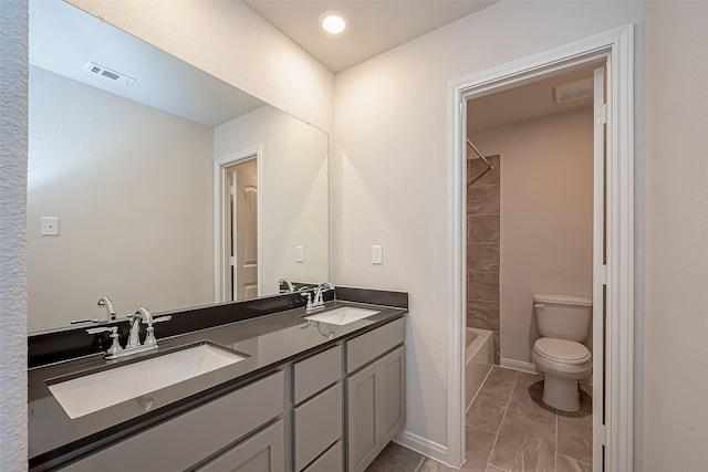 full bathroom with vanity, toilet, and tiled shower / bath