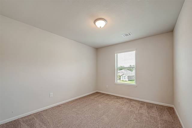 carpeted empty room with a textured ceiling