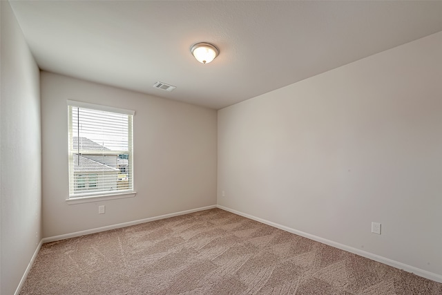 spare room featuring light colored carpet